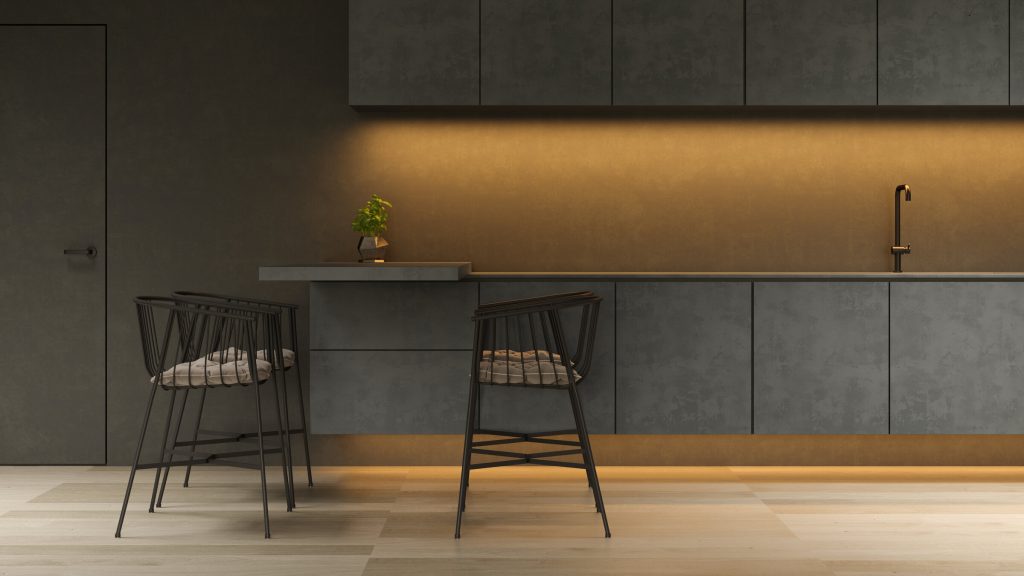 A dark grey kitchen with brass strip lighting under the cabinets and a brass tap