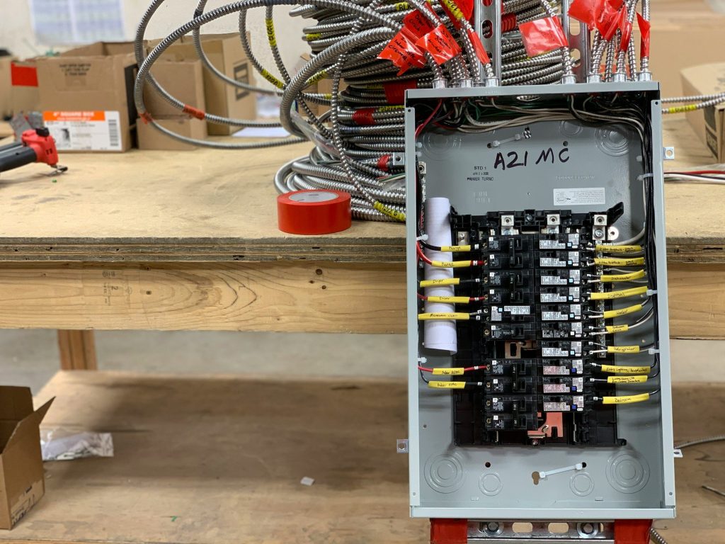 An open breaker panel with its circuits labelled for the range, dryer, dishwasher and refrigerator
