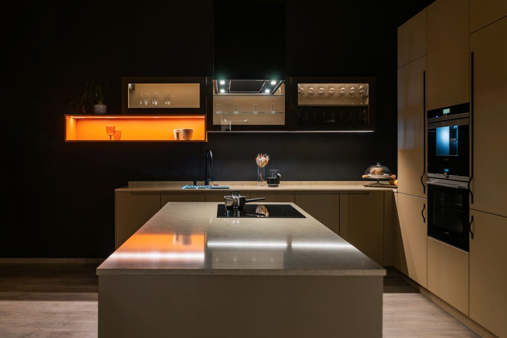 Dark modern kitchen with an island and warm shelf lighting