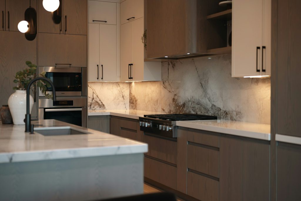 A marble backsplash running behind a range in a walnut and cream kitchen
