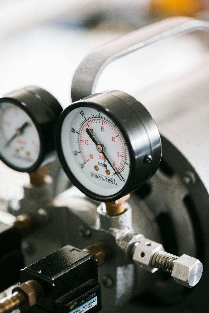 Two pressure gauges mounted on refrigeration machinery, read at close range